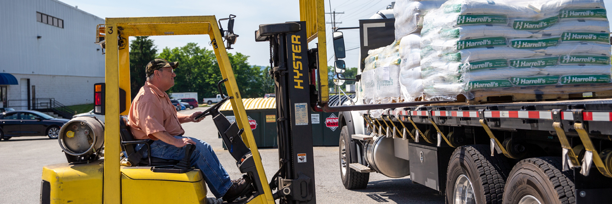 forklift loading fertilizer on a truck